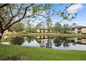 Tranquil lakefront property with lush landscaping and building reflections at 2679 Sabal Springs Cir # 203, Clearwater, FL 33761