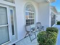 Inviting front porch with seating area, decorative windows, and stylish exterior paint, perfect for relaxation at 9336 Villa Entrada, New Port Richey, FL 34655