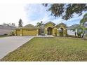 Beautiful one-story house featuring a three-car garage and lush landscaping at 9415 Sayre St, Riverview, FL 33569