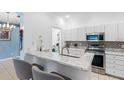 Bright kitchen features white cabinets, stainless steel appliances, granite countertops, and a stylish mosaic backsplash at 3203 Audubon Ct, Tarpon Springs, FL 34688