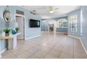 An open-concept living room featuring light blue walls, tile floors, and lots of natural light from the windows at 3203 Audubon Ct, Tarpon Springs, FL 34688