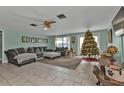 Spacious living room featuring a sofa, ottoman, and a Christmas tree at 512 Acacia Ln, Nokomis, FL 34275