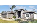 Curb appeal! Gray house with palm trees and well-manicured lawn at 5156 Mentmore Ave, Spring Hill, FL 34606