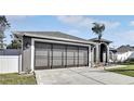 Gray house with a three-car garage and nicely landscaped yard at 5156 Mentmore Ave, Spring Hill, FL 34606