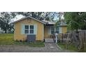 Cute yellow cottage with solar panels, small deck, and fenced yard at 6404 Pershing Ne St, St Petersburg, FL 33702