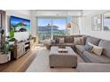 Bright living room with a large sectional sofa, wood floors, and sliding doors to the balcony at 912 Channelside Dr # 2601, Tampa, FL 33602