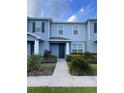 Charming townhome with manicured lawn and garden, with a covered porch and dark front door at 2409 Hearth Dr, Odessa, FL 33556