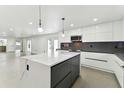 Modern kitchen with white cabinets, marble island, and stainless steel appliances at 26728 Hickory Loop, Lutz, FL 33559