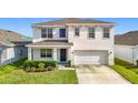 Two-story house with white exterior, two-car garage, and landscaped front yard at 34314 Jasper Stone Dr, Wesley Chapel, FL 33543