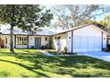 One-story house with attached garage, and landscaped lawn at 8040 Pasadena Dr, Port Richey, FL 34668