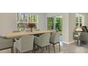 Dining room with light wood table and six gray chairs, overlooking backyard at 32714 Osprey Peak Way, San Antonio, FL 33576