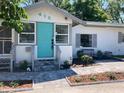 Charming single-story home with blue door, mature landscaping and inviting curb appeal at 415 21St N St, St Petersburg, FL 33713