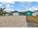 Teal house exterior with paver driveway and 2-car garage at 6926 Williams Dr, Tampa, FL 33634