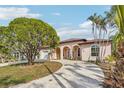 Beautiful light pink house with a large circular driveway and mature landscaping at 5269 61St N Way, Kenneth City, FL 33709
