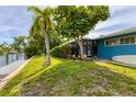 Landscaped backyard with canal access, and tropical foliage at 616 Lyons Ln, Longboat Key, FL 34228