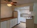 Functional kitchen with white cabinetry, matching appliances, and laminate countertops at 6177 Chesham Dr # 6, New Port Richey, FL 34653