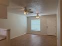 Neutral-toned living room featuring wood-look flooring, two ceiling fans, and ample natural light at 6177 Chesham Dr # 6, New Port Richey, FL 34653