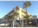 Condo building exterior showcasing a well-maintained building with palm trees and signage at 215 Valencia Blvd # 105, Belleair Bluffs, FL 33770