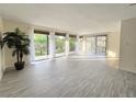 Bright living room with tile floors and access to balcony with floor to ceiling sliding doors and large potted plant at 3031 Countryside Blvd # 35C, Clearwater, FL 33761