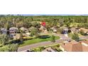 Aerial view of homes in a neighborhood near a lush golf course surrounded by mature trees at 4275 Caskie Pl, Brooksville, FL 34604