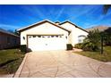 Well-maintained one-story home with a two-car garage, beautiful landscaping, and a patterned driveway at 11021 Edge Park Dr, Hudson, FL 34667