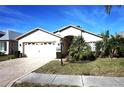 Inviting single-story home showcasing a well-manicured lawn, mature landscaping, and a two-car garage at 11021 Edge Park Dr, Hudson, FL 34667