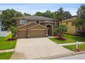 Beautiful two-story home with a spacious driveway, three-car garage, and lush, green lawn at 15815 Muirfield Dr, Odessa, FL 33556