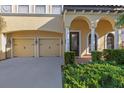 A spacious two-story home with a tile roof, arched front porch, a two-car garage, and lush green landscaping at 20314 Chestnut Grove Dr, Tampa, FL 33647