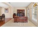 Spacious office featuring a large wooden desk, built-in shelving, and natural light from the large windows at 20314 Chestnut Grove Dr, Tampa, FL 33647
