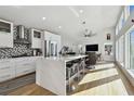 Modern kitchen featuring a large island, stainless steel appliances, mosaic backsplash, and bright natural light at 21 Crescent S Pl, St Petersburg, FL 33711