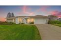 Single Gathering home with an arched doorway, two-car garage, and well maintained lawn at 7233 15Th Ne Ct, St Petersburg, FL 33702
