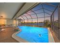 Inviting screened-in pool offering a serene lake view, perfect for relaxation and entertainment at 7233 15Th Ne Ct, St Petersburg, FL 33702