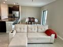 Comfortable sectional sofa positioned near the kitchen and dining area for easy living at 13621 Willow Bluestar Loop, Riverview, FL 33579