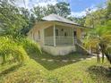 Quaint home featuring a covered porch, lush greenery, and a peaceful setting at 262 Pryor St, Brooksville, FL 34601