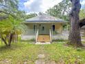 Inviting home featuring a classic covered front porch and lush landscaping at 262 Pryor St, Brooksville, FL 34601