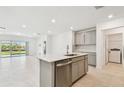 Bright kitchen features stainless steel appliances, gray cabinets, an island, and an open view to the backyard at 6233 Golden Beach Dr, Apollo Beach, FL 33572