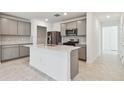 Modern kitchen with gray cabinets, stainless steel appliances, white countertops, and a central island with a sink at 6233 Golden Beach Dr, Apollo Beach, FL 33572