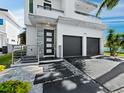 Modern home with dark garage doors, decorative stone accents, complemented by clean landscaping and a paver walkway at 2246 Fiesta Dr, Sarasota, FL 34231