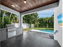 Wonderful covered patio area with outdoor kitchen and a relaxing view of the pool at 2246 Fiesta Dr, Sarasota, FL 34231