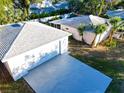 Aerial view of a home and detached garage featuring large driveway, palm trees and lush landscaping at 2514 Ohio S Ct, Gulfport, FL 33707