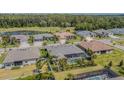 Aerial view of a residential neighborhood featuring manicured lawns, mature trees, and a golf course at 3815 Gaviota Dr, Wimauma, FL 33598