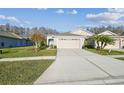 Inviting home with manicured lawn, charming front yard, and a spacious driveway at 2932 Tanglewylde Dr, Land O Lakes, FL 34638