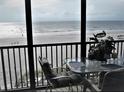 Relaxing balcony view overlooking the sandy beach and ocean, complete with comfortable seating and a welcome sign at 20040 Gulf Blvd # 302, Indian Shores, FL 33785