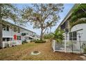 An apartment backyard featuring a large tree and white picket fence at 4140 55Th N St # 1211, Kenneth City, FL 33709