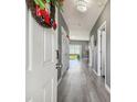 Inviting entryway with gray floors and a charming wreath on the white front door at 451 Hartford Heights St, Spring Hill, FL 34609