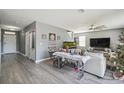 Open-concept living room with gray floors, a ceiling fan, and ample space for furniture at 451 Hartford Heights St, Spring Hill, FL 34609