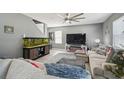 Comfortable living room featuring a large sofa, an aquarium, and a ceiling fan at 451 Hartford Heights St, Spring Hill, FL 34609