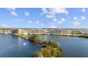 Beautiful aerial view of waterfront condos surrounded by lush greenery, a bay, and blue skies at 6009 Sea Ranch Dr # 303, Hudson, FL 34667