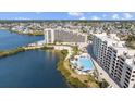 Stunning aerial view of condos with a pool, lush landscaping, and a sandy beach at 6009 Sea Ranch Dr # 303, Hudson, FL 34667