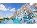 Resort-style pool with lounge chairs and umbrellas in a condo complex overlooking the beach at 1350 Gulf Blvd, Clearwater, FL 33767